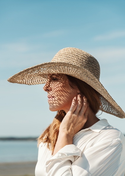 kvinna i solhatt med ekologiska solprodukter från maria åkerberg